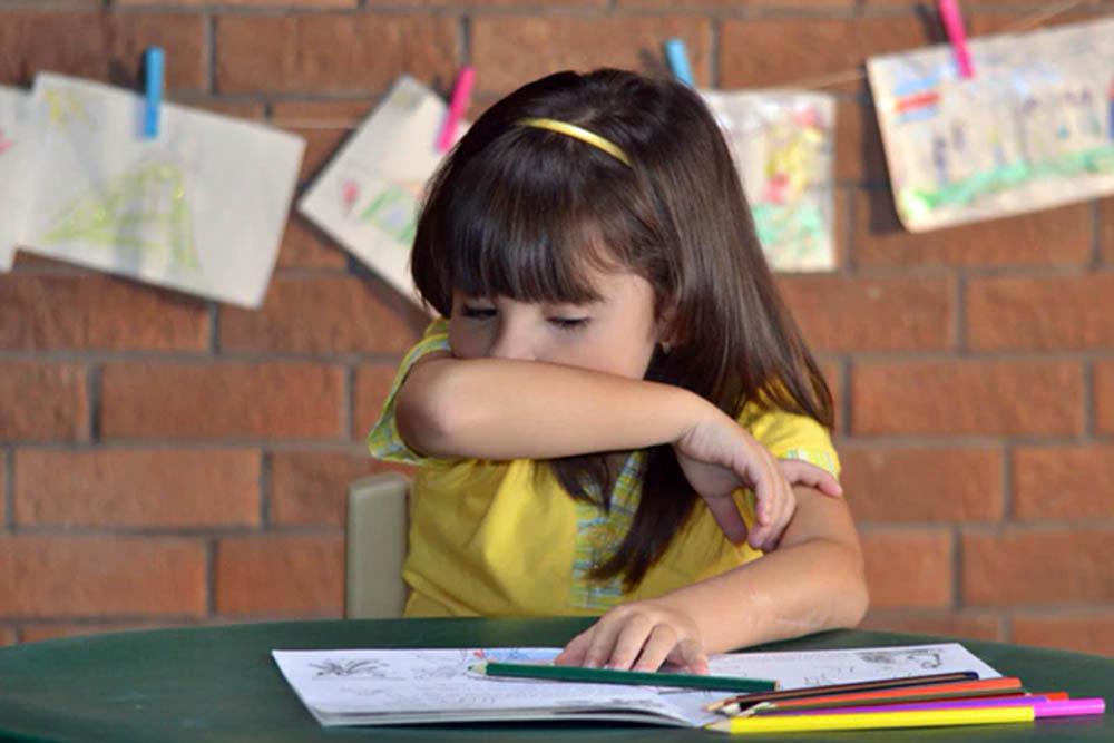 Niña estornudando